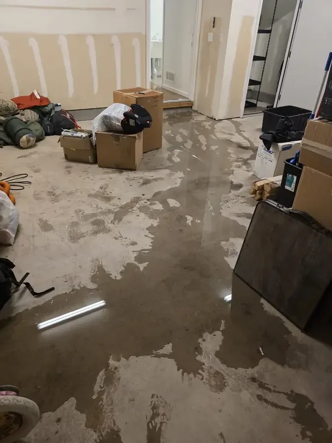 A flooded finished basement with the water being pumped out